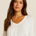 CAMISETA BLANCA CON ESTAMPADO FRONTAL HACIENDO AGUAS, ESCOTE DE PICO Y MANGA LARGA