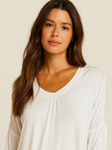 CAMISETA BLANCA CON ESTAMPADO FRONTAL HACIENDO AGUAS, ESCOTE DE PICO Y MANGA LARGA