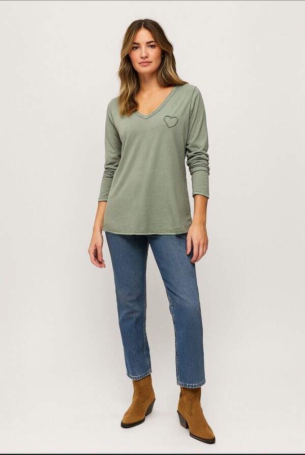CAMISETA DE ALGODÓN VERDE KAKI, ESCOTE DE PICO Y MANGA LARGA. DETALLE DE CORAZÓN PEQUEÑO EN EL LATERAL IZQUIERDO