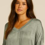 CAMISETA VERDE OLIVA CON ESTAMPADO FRONTAL HACIENDO AGUAS, ESCOTE DE PICO Y MANGA LARGA